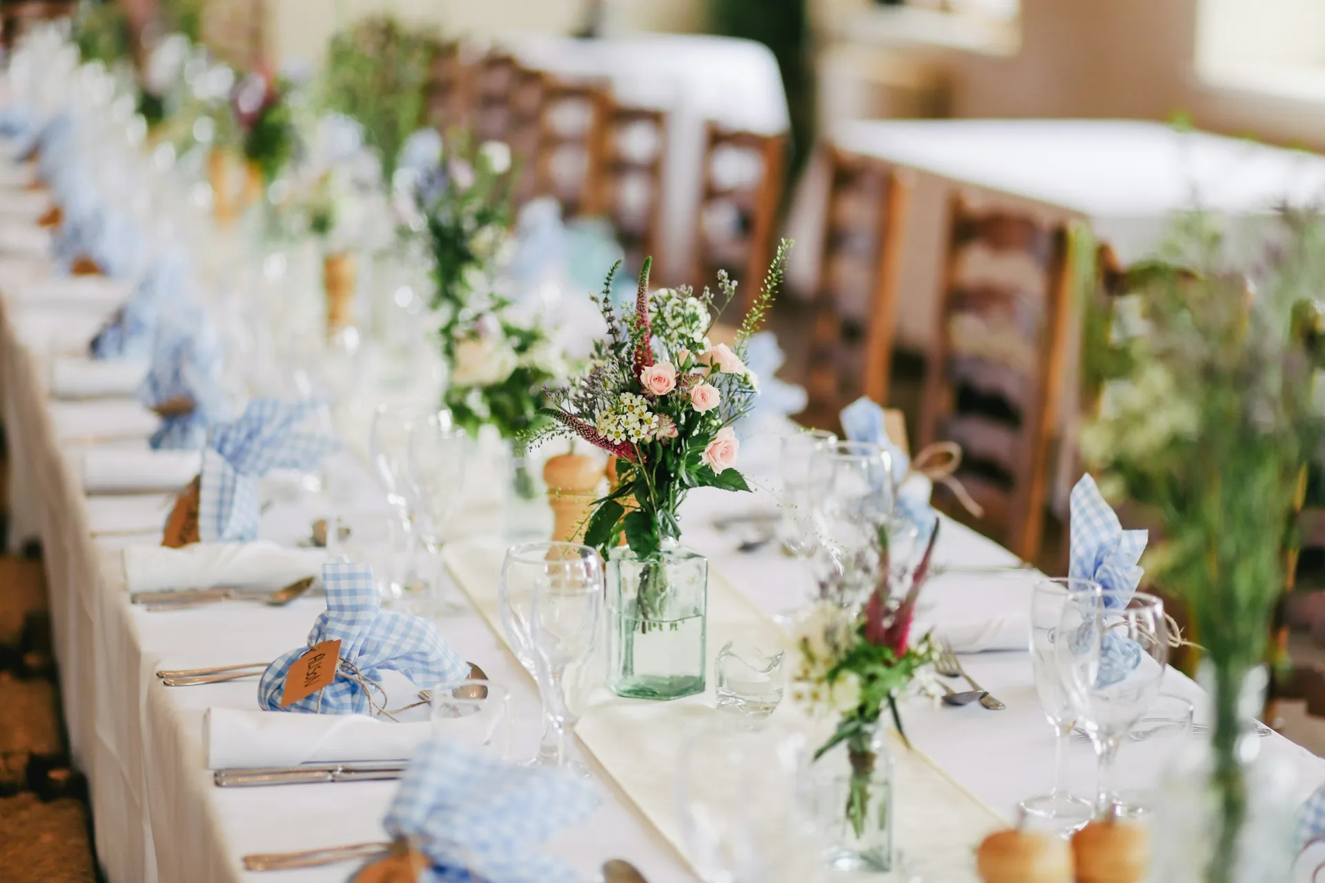 Décoration florale élégante sur une table de réception de mariage, ambiance chaleureuse et raffinée.